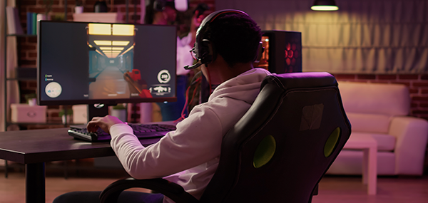 Imagen del botón: Sillas Gamer - Gamer de espalda sentado en silla gamer jugando videojuegos