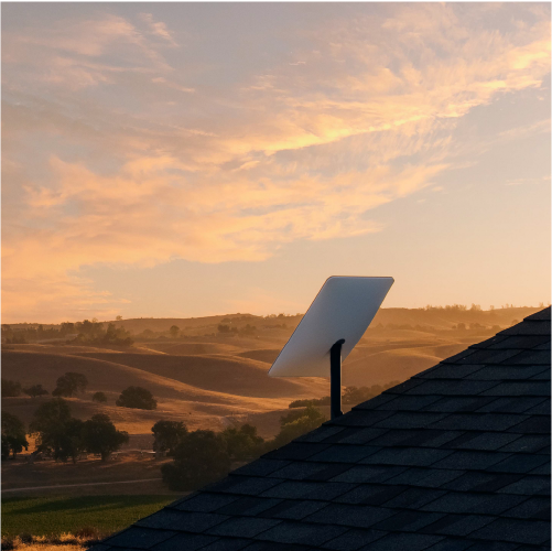 fotografía de una antena de starlink sobre el techo de una casa en alguna clase de desierto o pampa